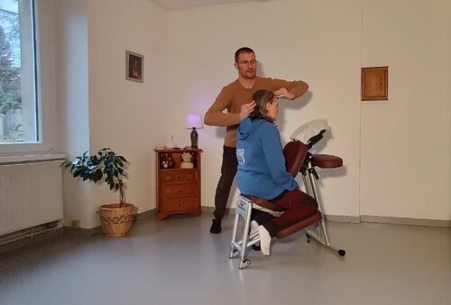 Amma'Dam procédant à un massage Amma assis sur une femme (front et crâne)